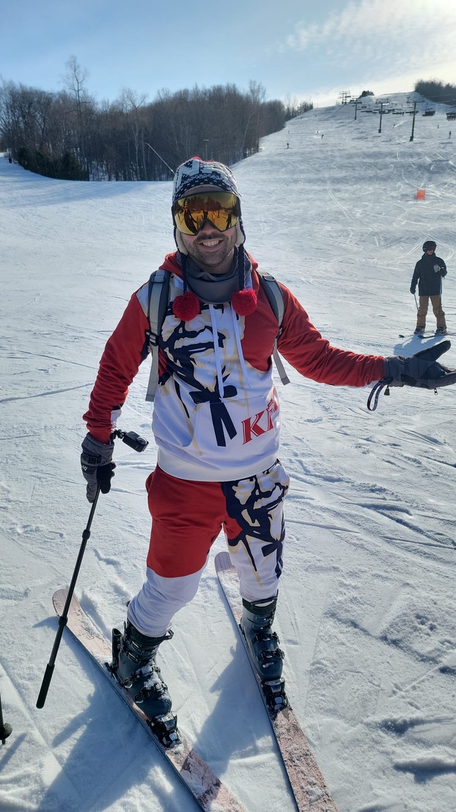 Bogdan Rus skiing, smiling on a snowy slope.